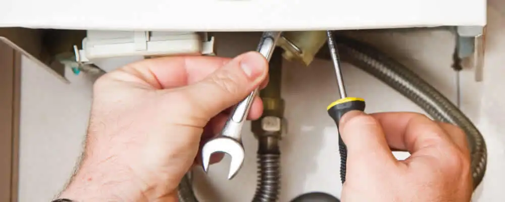 Boiler repair technician tightening pipe fittings and connections in West Palm Beach, FL