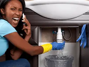 Emergency plumbing repair for a leaking sink drain under a bathroom vanity in West Palm Beach, FL