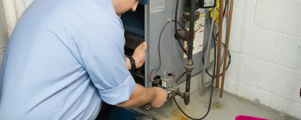 Furnace repair technician inspecting and servicing a home heating system in West Palm Beach, FL