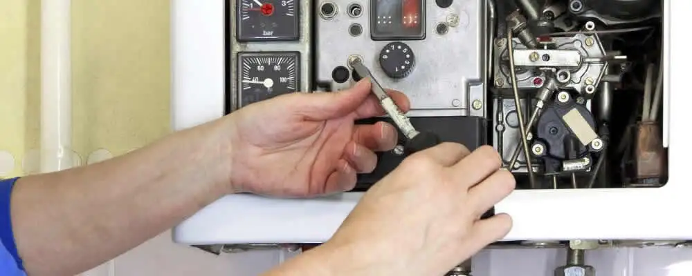 Heating repair technician adjusting boiler controls and components in West Palm Beach, FL