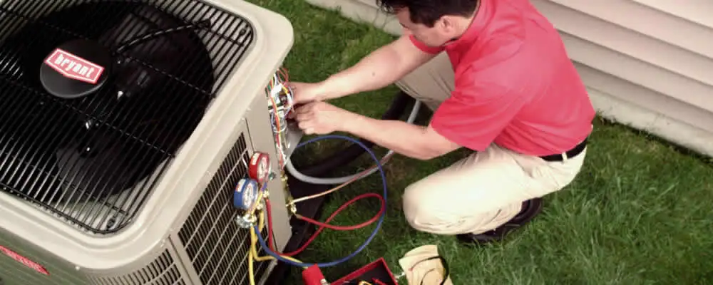 HVAC technician servicing an outdoor air conditioner unit in West Palm Beach, FL