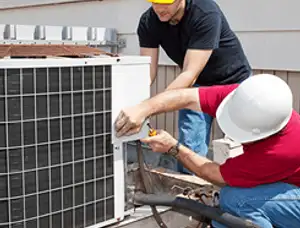 HVAC technicians repairing an outdoor AC unit on a rooftop in West Palm Beach, FL