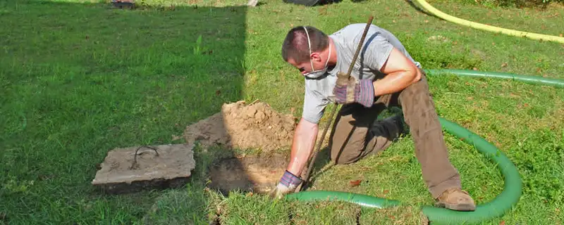 Septic pumping technician servicing a residential septic tank in West Palm Beach, FL