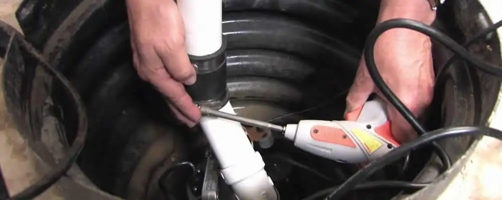 Sump pump installation technician connecting PVC discharge piping in West Palm Beach, FL